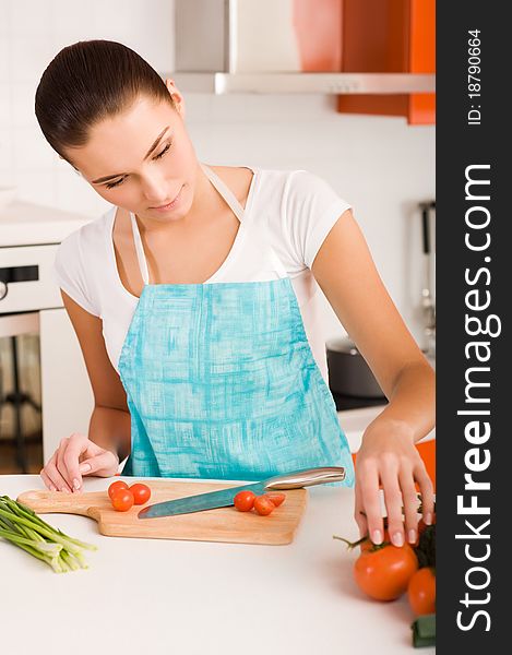 Young Woman cutting vegetables in a kitchen