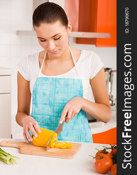 Young woman cutting vegetables in a kitchen