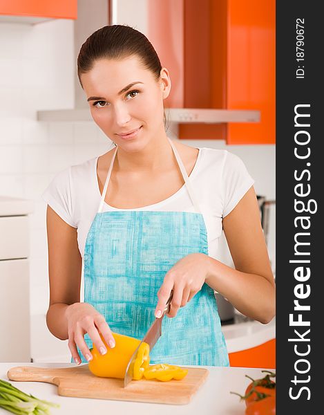 Young Woman cutting vegetables in a kitchen