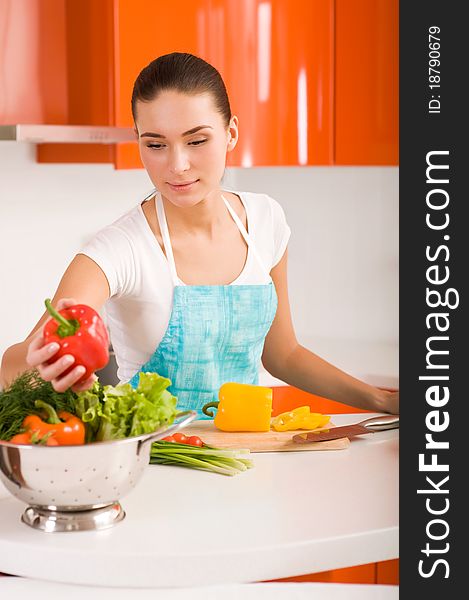 Woman cutting vegetables in modern kitchen