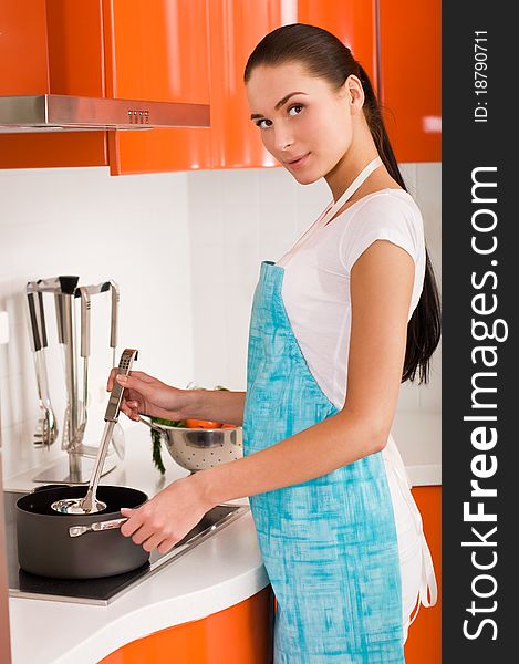 Beautiful young woman cooking in the kitchen