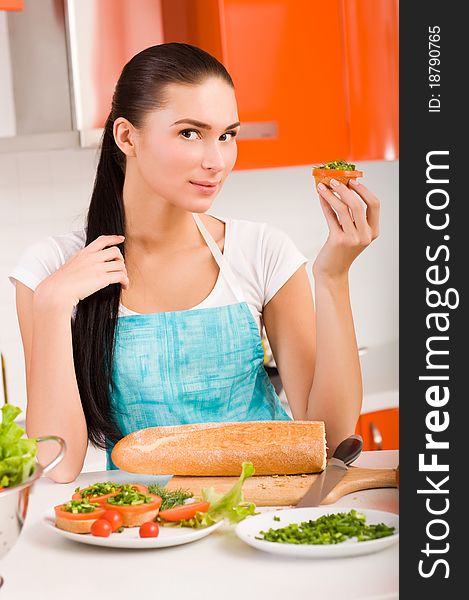 Attractive smiling woman preparing fresh healthy sandwiches in her kitchen