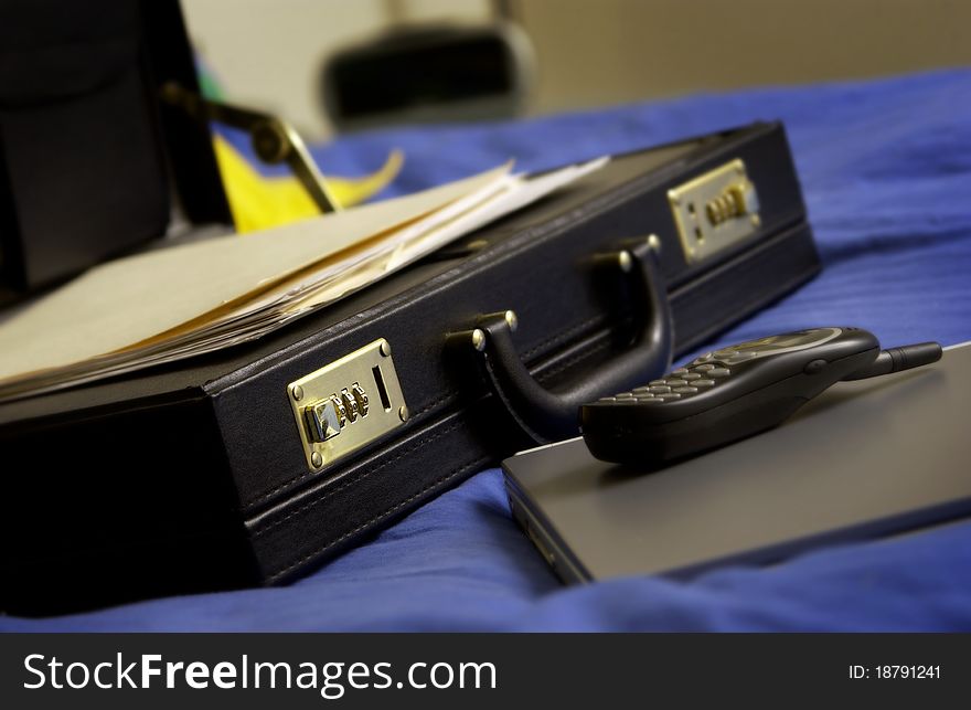 Open briefcase with laptop, phone and papers