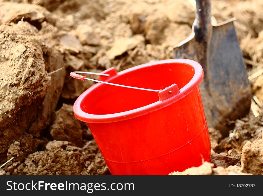 Red Bucket and Shovel on ground. Red Bucket and Shovel on ground