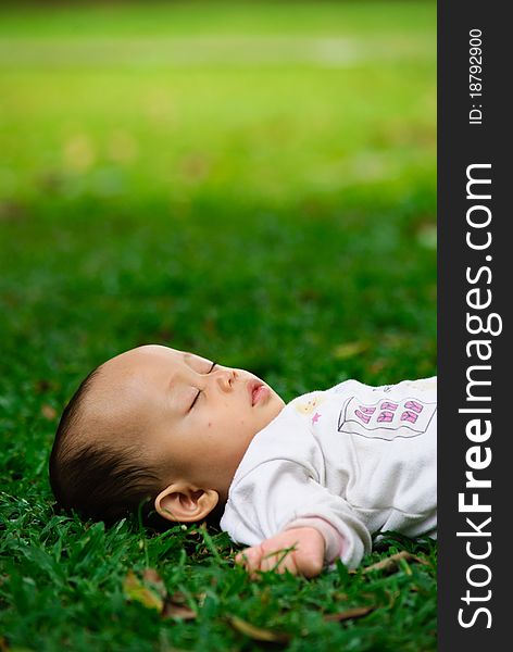 Baby boy is sleeping in a park after feeding time