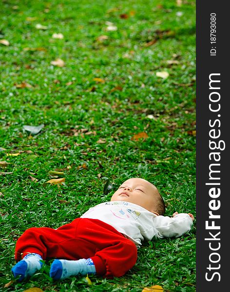 Baby boy is sleeping in a park after feeding time