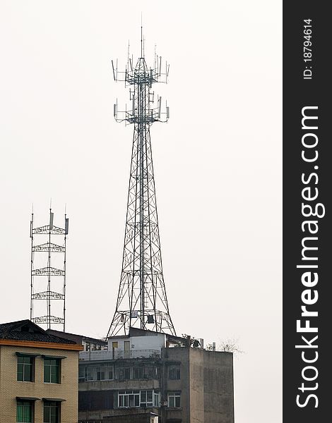 Base station antenna tower on the buildings in a small town. Base station antenna tower on the buildings in a small town.