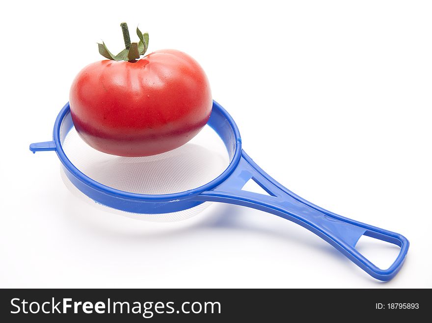Tomato in the kitchen sieve of plastic
