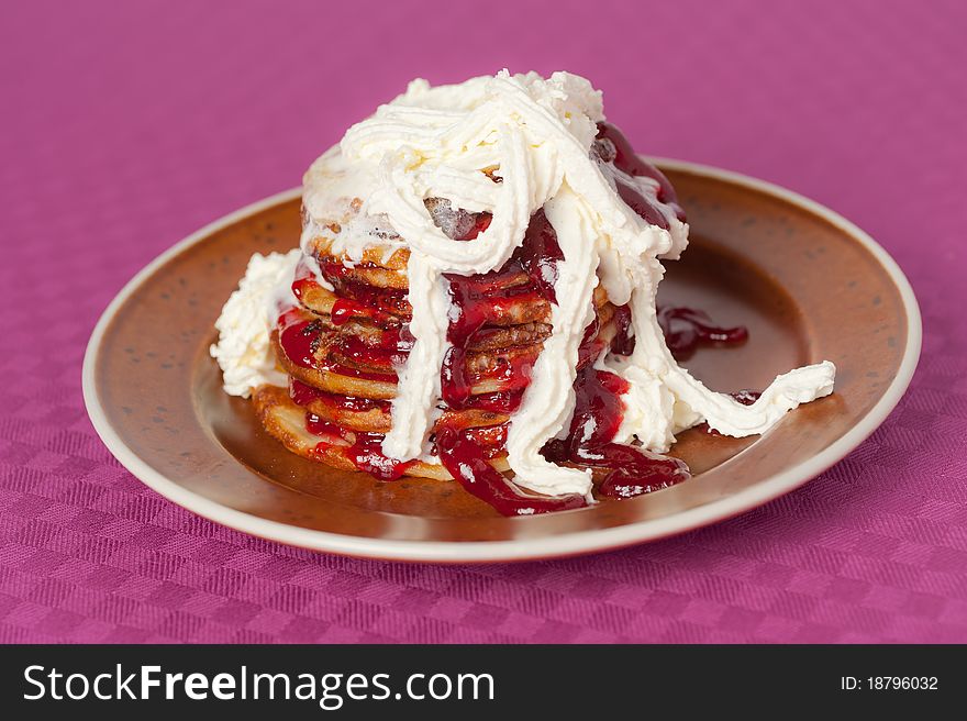 Mess of unhealthy pancakes with jam and cream. Mess of unhealthy pancakes with jam and cream
