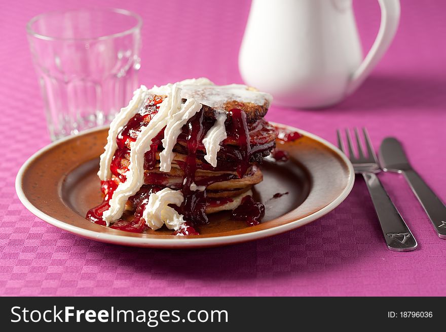 Mess of unhealthy pancakes with jam and cream. Mess of unhealthy pancakes with jam and cream