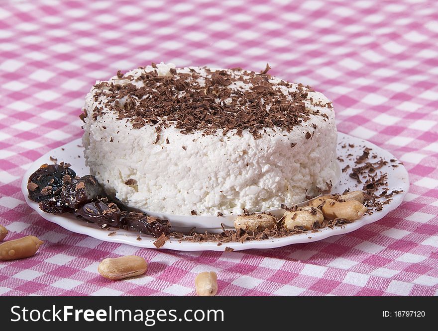 Dairy breakfast, cottage cheese on a plate, strewed by a chocolate crumb on white background