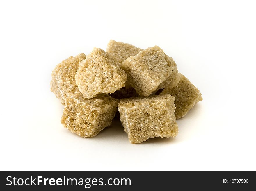 Pile of brown sugar cubes over white