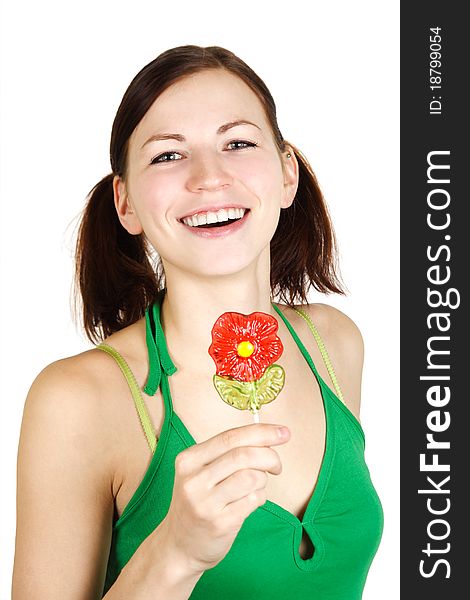 Young girl in green shirt holding flower lollipop and smiling, isolated