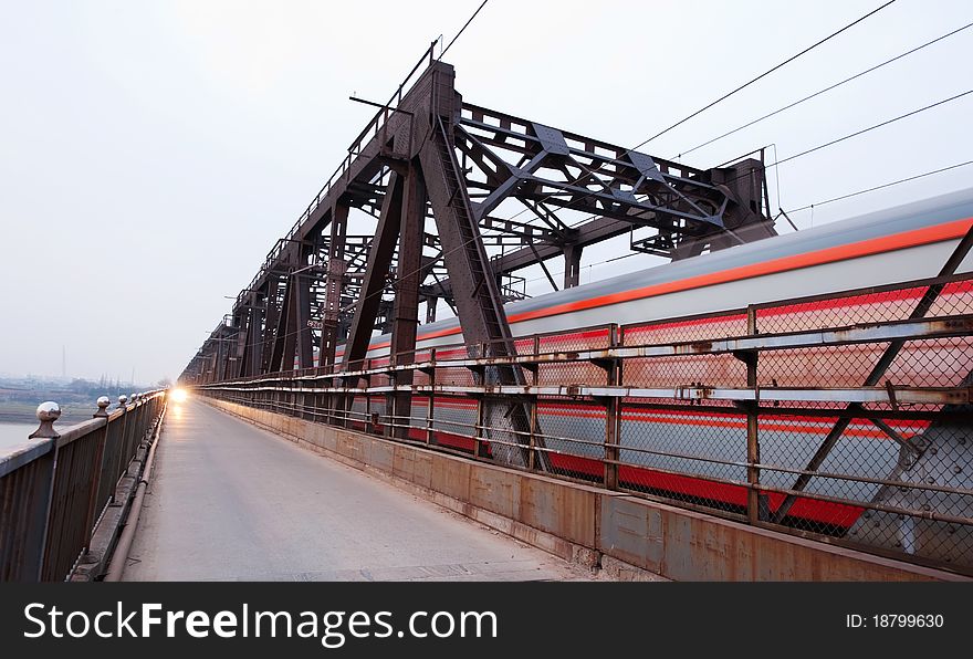 A railway bridge, the train cars and pedestrians