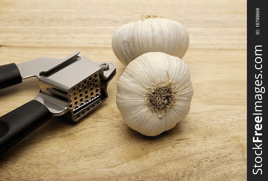 Garlic press and two cloves of garlic