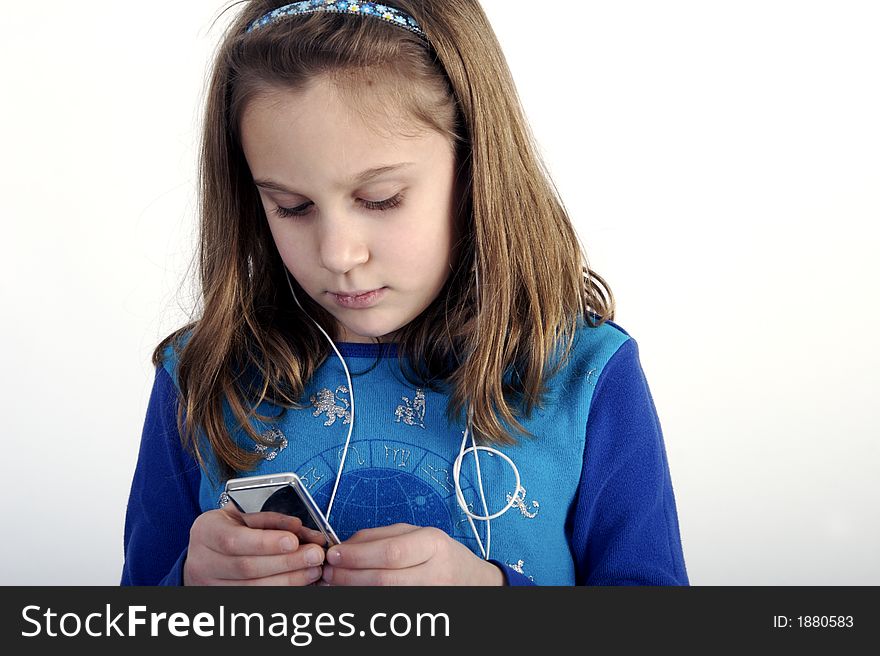 Young elementary-school age girl lisening to a portable music player. Young elementary-school age girl lisening to a portable music player