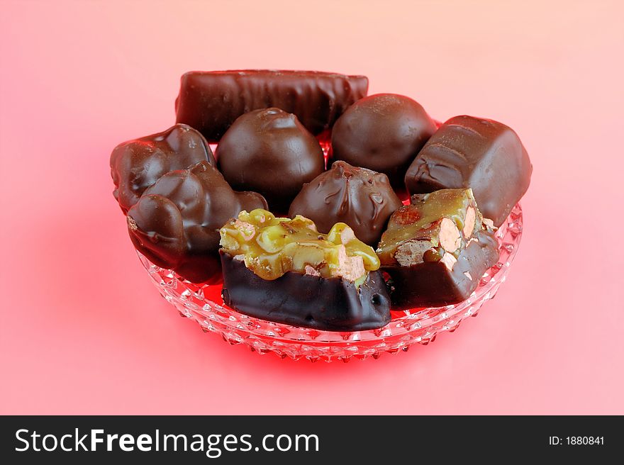 An assortment of chocolates arranged on a glass dish with a Peach colored background. An assortment of chocolates arranged on a glass dish with a Peach colored background.