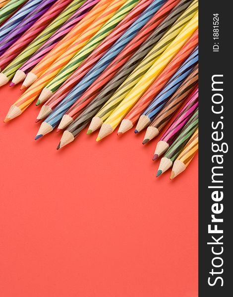 Coloured Pencils set against a Plain Background.