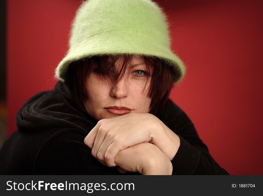 Cute read head woman with a green Hat over red background. Cute read head woman with a green Hat over red background