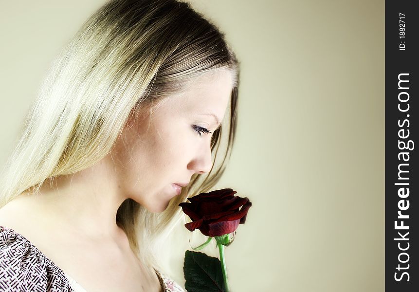 Portrait of a fresh, beautiful young blond woman with a red rose in her hand - valentine ´s day