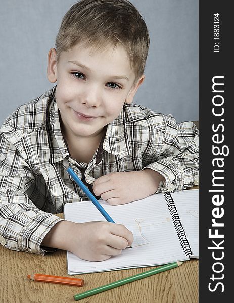 Smiling drawing boy with notepad and pencils. Smiling drawing boy with notepad and pencils