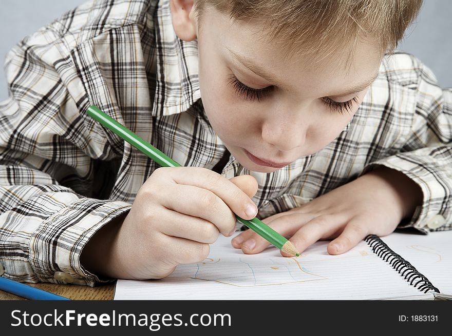 Serious drawing boy with notepad and pencil. Serious drawing boy with notepad and pencil