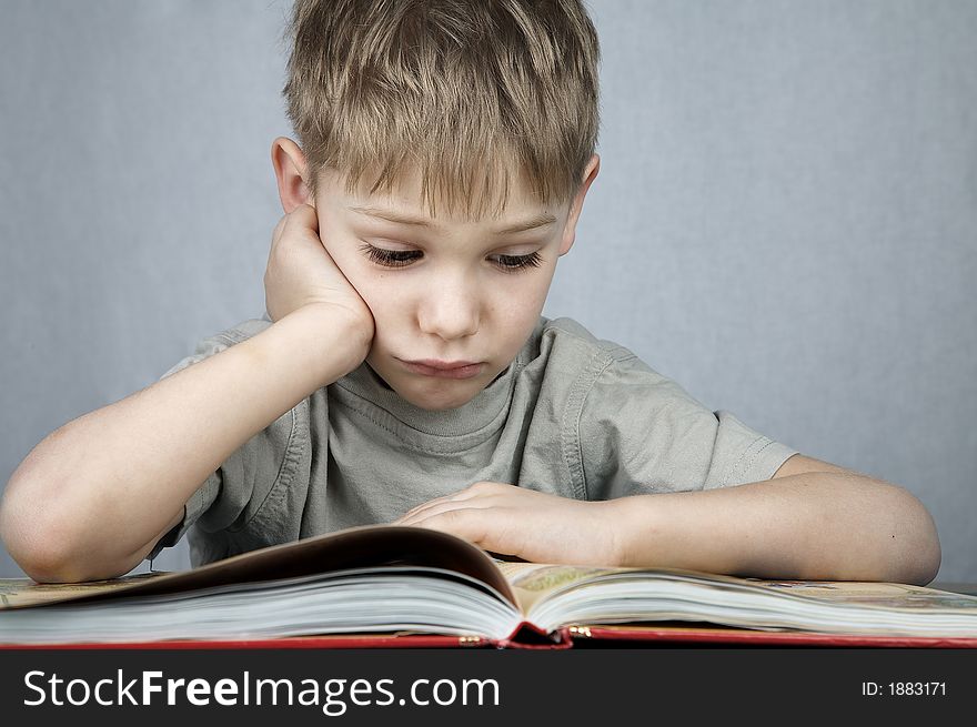 Little sad boy with big book. Little sad boy with big book