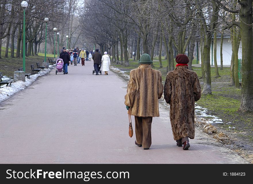 Two women in furs walking in the park