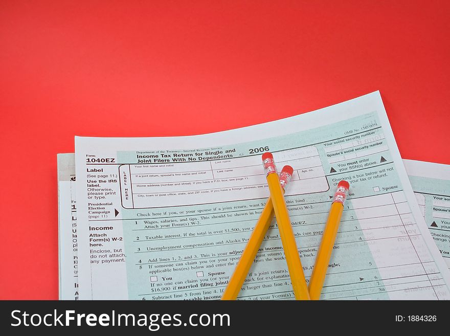 Tax forms and pencils on a red background. Tax forms and pencils on a red background