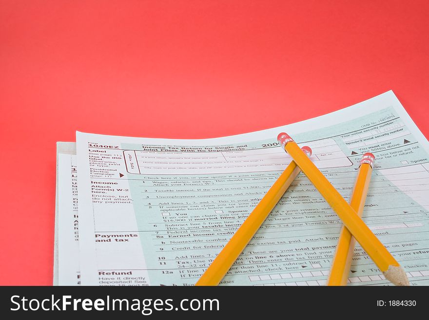 Tax forms and pencils on a red background. Tax forms and pencils on a red background