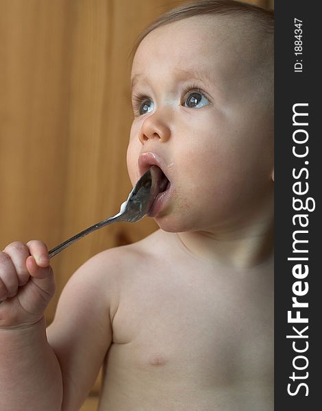 Image of baby eating yogurt from a spoon. Image of baby eating yogurt from a spoon