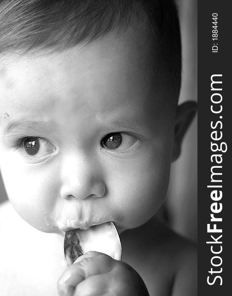 Image of baby eating yogurt from a spoon. Image of baby eating yogurt from a spoon