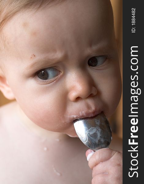 Image of baby eating yogurt from a spoon. Image of baby eating yogurt from a spoon