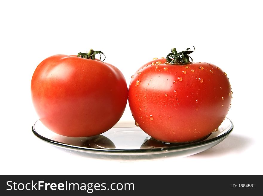 Dry and wet tomatoes at the plate on a white background