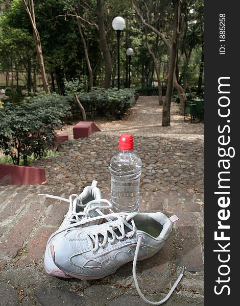 Sneakers and a bottle of water on a park