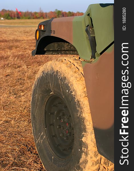 The muddy wheel of a military vehicle from a low angle. The muddy wheel of a military vehicle from a low angle