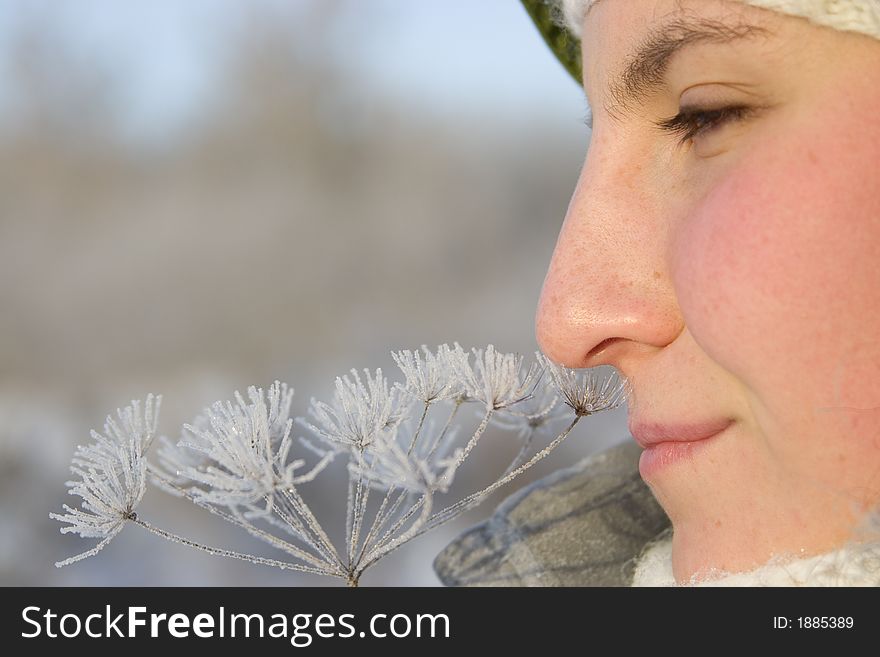 Beautiful girl smells snowy flower. Beautiful girl smells snowy flower