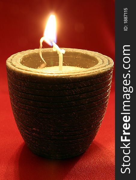 Candle with red silk background.