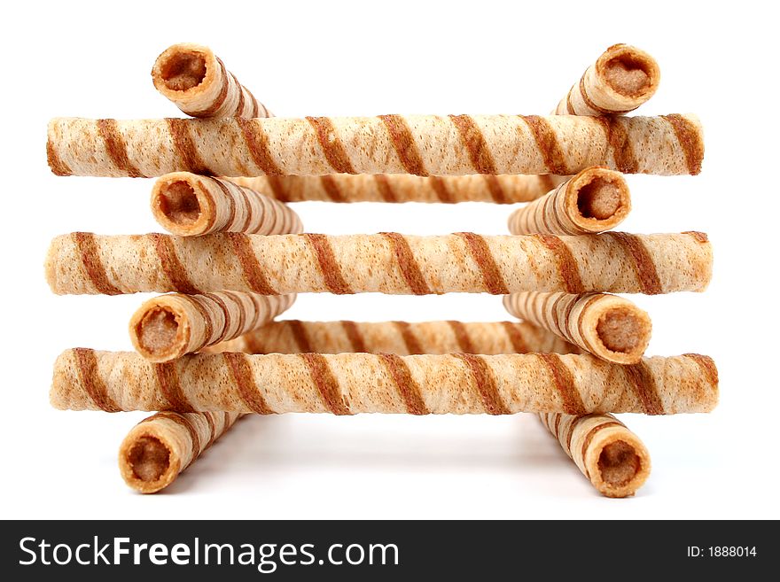 Heap of striped wafer tubules with the chocolate cream, isolated