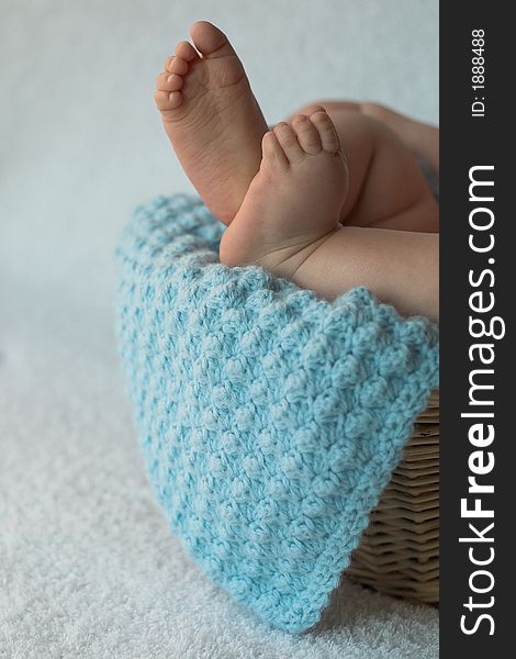 Image of baby toes peeking over the edge of a blanket-lined basket