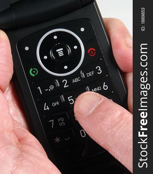 Hand holding mobile telephone with finger touching key. Hand holding mobile telephone with finger touching key