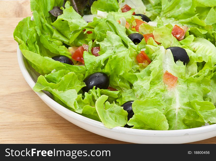 Vegetables salad in plate on wood background