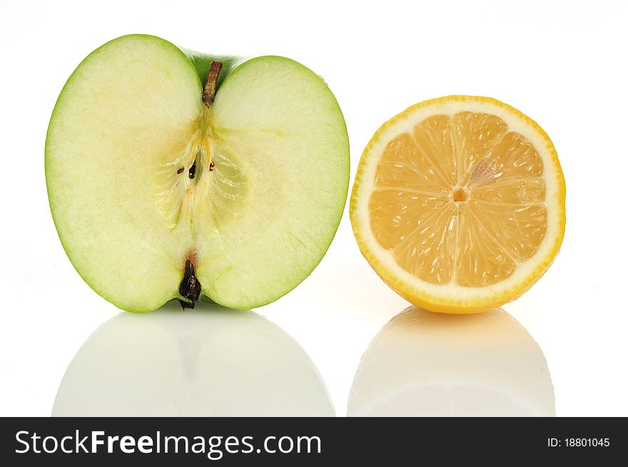 A half green apple and yellow lemon , on a white background. A half green apple and yellow lemon , on a white background.