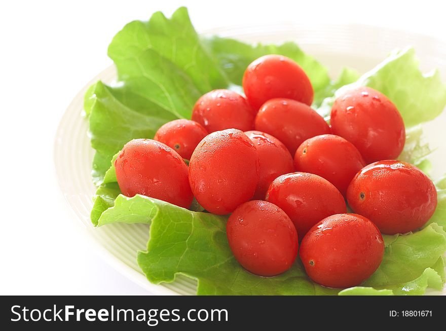 Fresh rosa tomatoes and butter lettuce on white plate. Fresh rosa tomatoes and butter lettuce on white plate