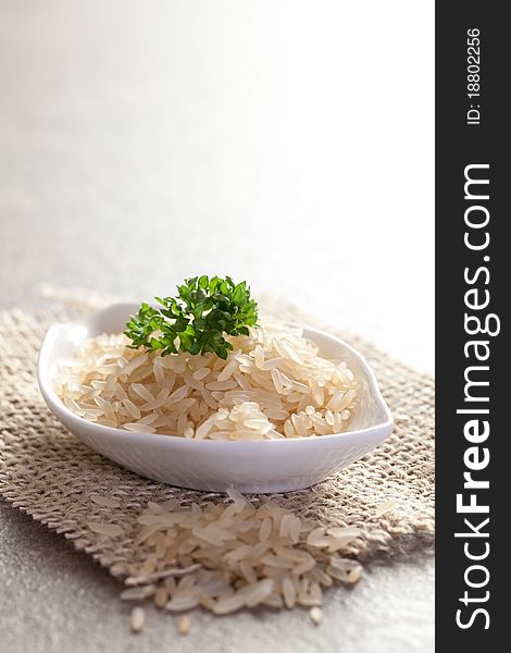 Raw rice in a bowl with parsley. Raw rice in a bowl with parsley