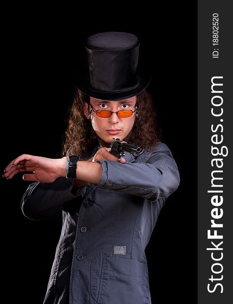 Portrait of the serious man in a top-hat with a pistol in hands