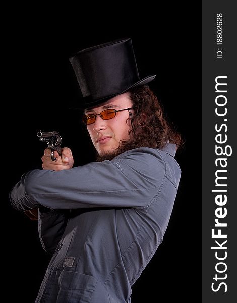 Portrait of the serious man in a top-hat with a pistol in hands
