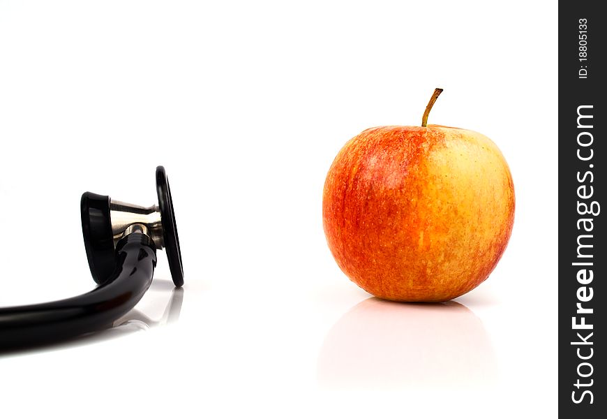 A stethoscope with a red apple with white background. A stethoscope with a red apple with white background