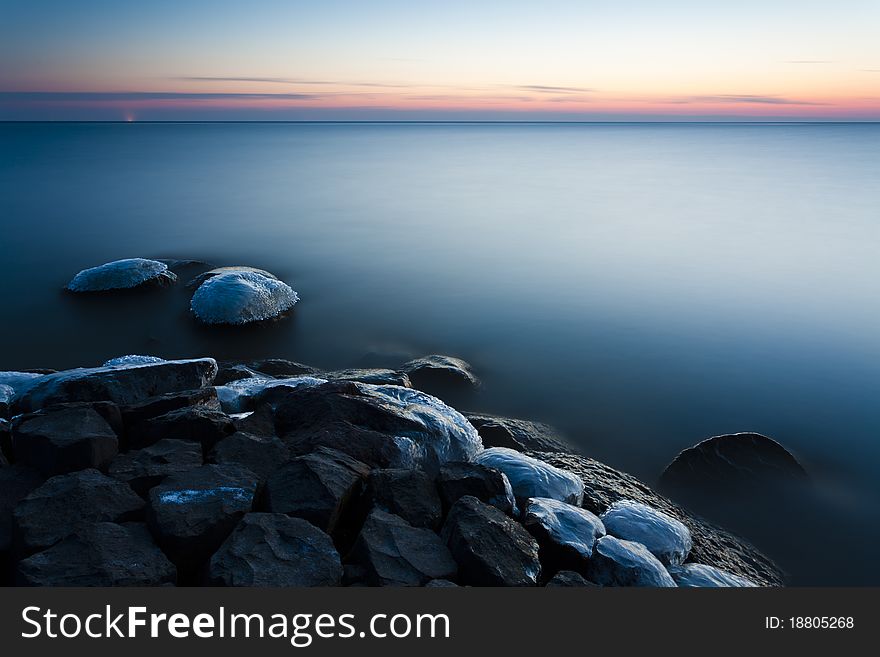 A tranquil and cold sunset at the IJsselmeer in the Netherlands. A tranquil and cold sunset at the IJsselmeer in the Netherlands