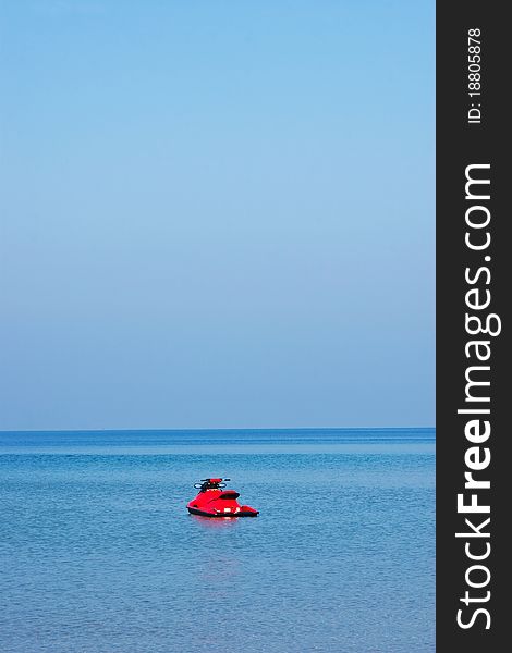 Lonely red jet ski on blue sea